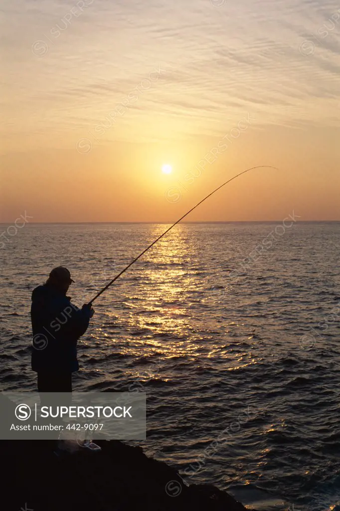 Silhouette of a fisherman fishing at sunset, Oshima Island, Japan
