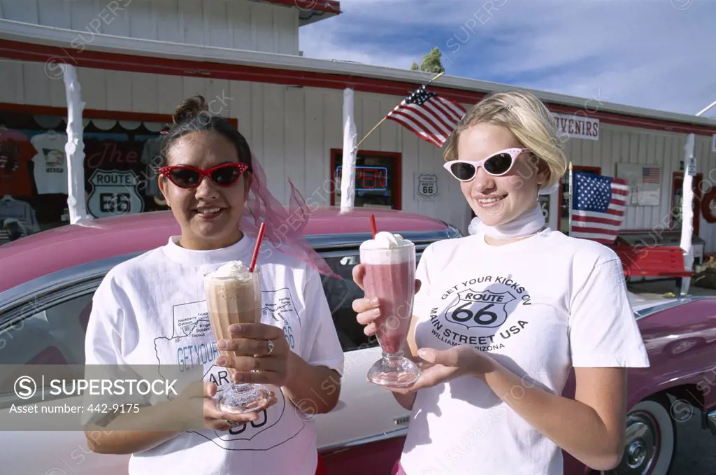 Two teenage girls holding ice cream floats, Twisters Soda Fountain, Route 66, Williams, Arizona, USA
