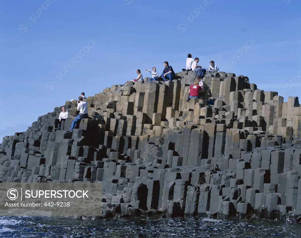 People on rocks at the coast, Giants Causeway, County Antrim, Northern Ireland