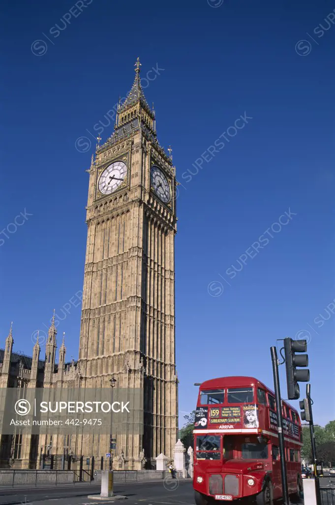 Low angle view of a double-decker bus in front of Big Ben and the Houses of Parliament, Westminster, London, England