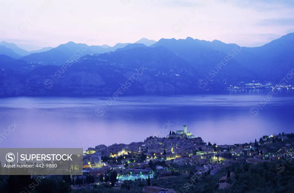 Aerial view of buildings lit up at dusk, Lake Garda, Malcesine, Italy