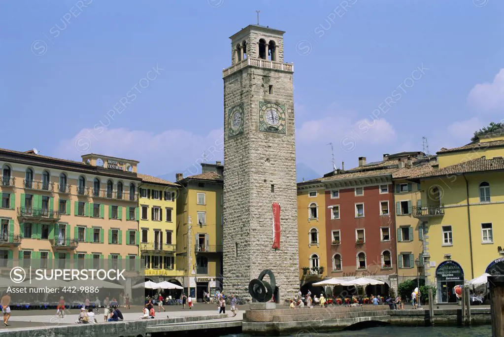 Low angle view of a clock tower in front of buildings, Aponale Tower, Riva del Garda, Italy