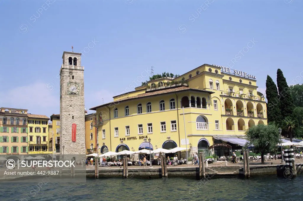 Clock tower in front of buildings, Aponale Tower, Riva del Garda, Italy