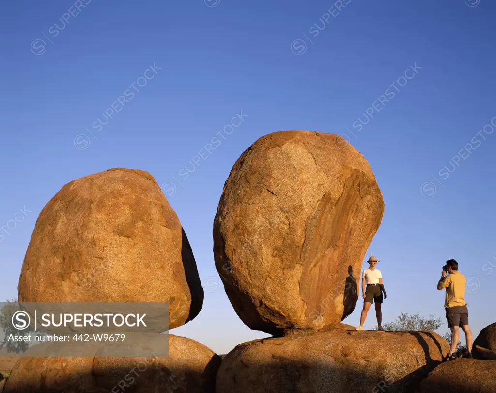Tourist taking photographs of boulders, Devils Marbles, Northern Territory, Australia
