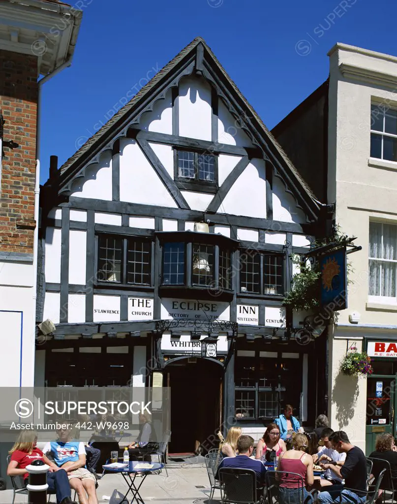 Tourists sitting in front of the Eclipse Inn, Winchester, Wiltshire, England