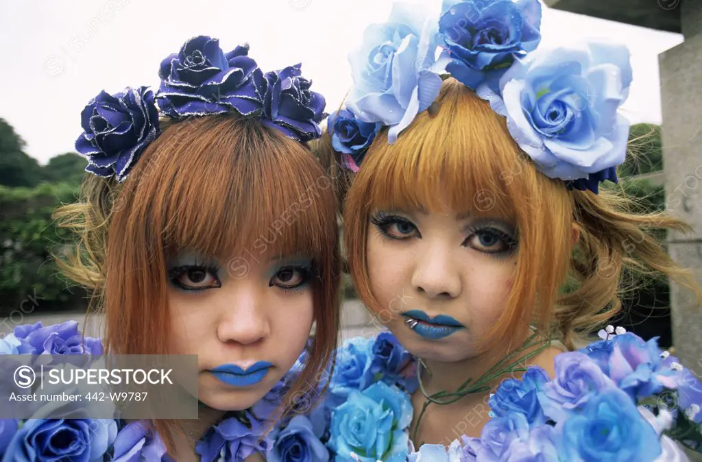 Portrait of two girls wearing flowers, Tokyo, Japan