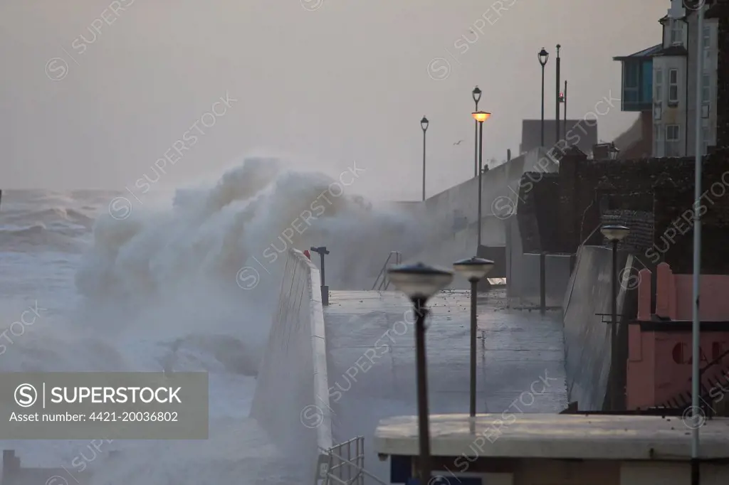 Waves crashing against seawall of seaside town during tidal surge, Sheringham, North Norfolk, England, December 2013