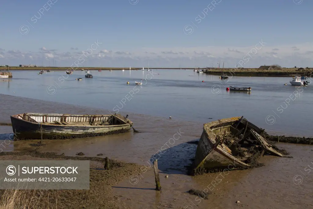Abandoned boats on the mud flats of the River Ore near Orford, Suffolk. Orford ness on the right.