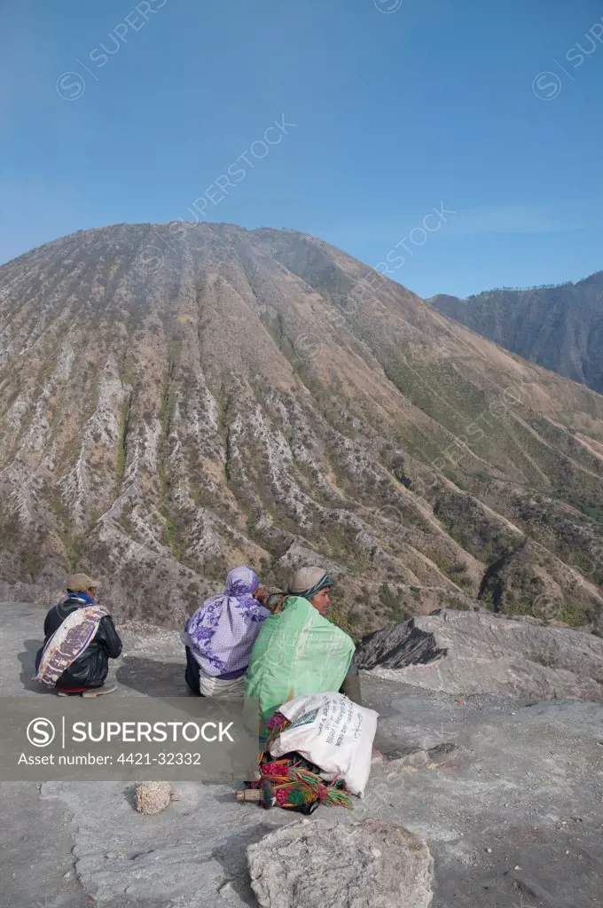 Men selling offerings on slope of volcano, Mount Batok in background, Mount Bromo, Bromo Tengger Semeru N.P., East Java, Indonesia