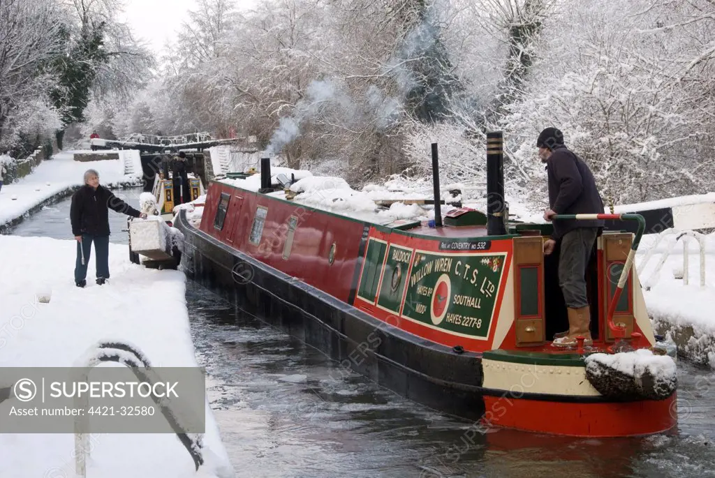 Narrowboats in snow, negotiating thick ice at locks, Grand Union Canal, Berkhamsted, Hertfordshire, England, winter