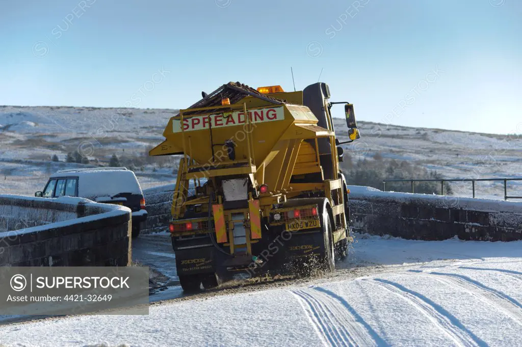 Council gritter lorry gritting snow covered rural road, Whitewell, Lancashire, England, november
