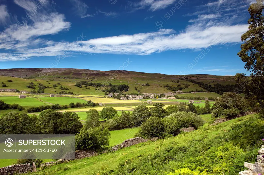 View across River Swale towards village of Gunnerside, Swaledale, Yorkshire Dales, North Yorkshire, England, july