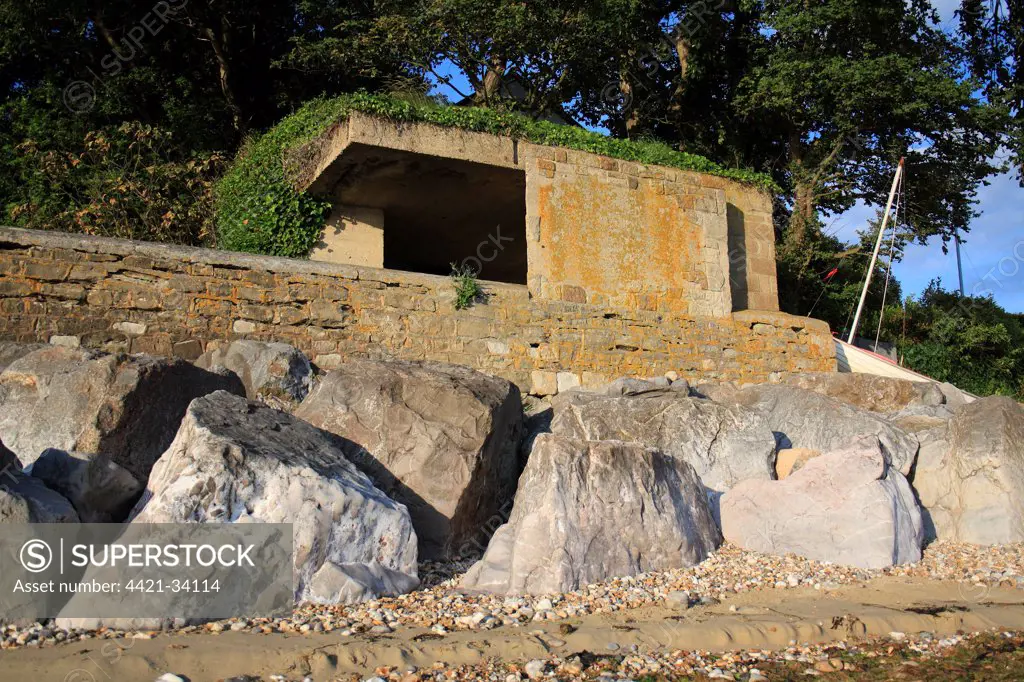 World War Two gun emplacement and riprap boulders at edge of beach, Bembridge, Isle of Wight, England, june