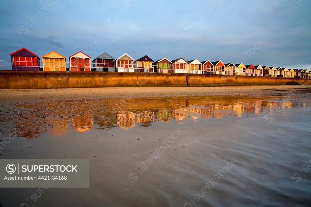 Beach huts on seawall of seaside resort at sunrise, Southwold, Suffolk, England, april