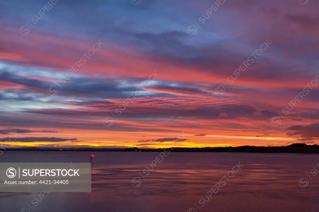 View over river estuary at dawn, with navigation light in foreground, viewed from Beachley looking towards Monmouthshire, River Severn, Severn Estuary, Gloucestershire, England, october