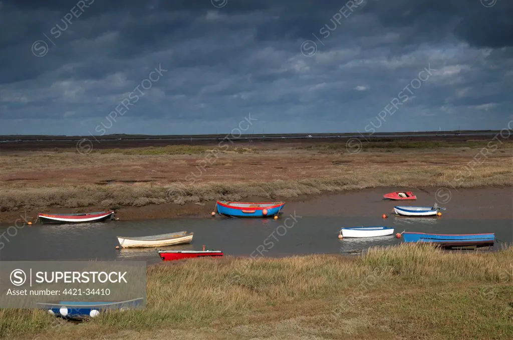 View of coastal saltmarsh and boats moored in creek, Morston Quay, Norfolk, England, october