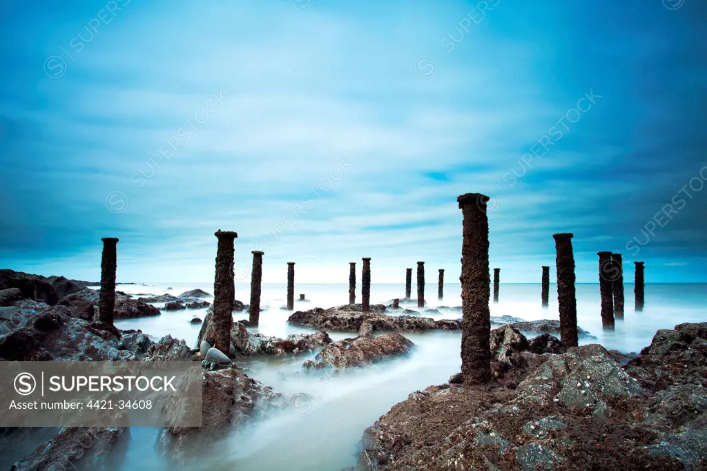 Steel stantions of ruined Victorian pier visable on shore at low tide, Westward Ho!, North Devon, England, april