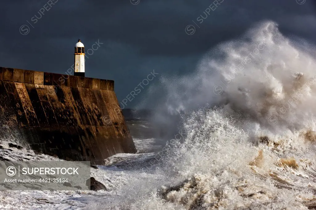 Coastal resort town seafront and lighthouse bombarded by waves during storm, Porthcawl Pier, Porthcawl, Bristol Channel, South Wales, Wales, september