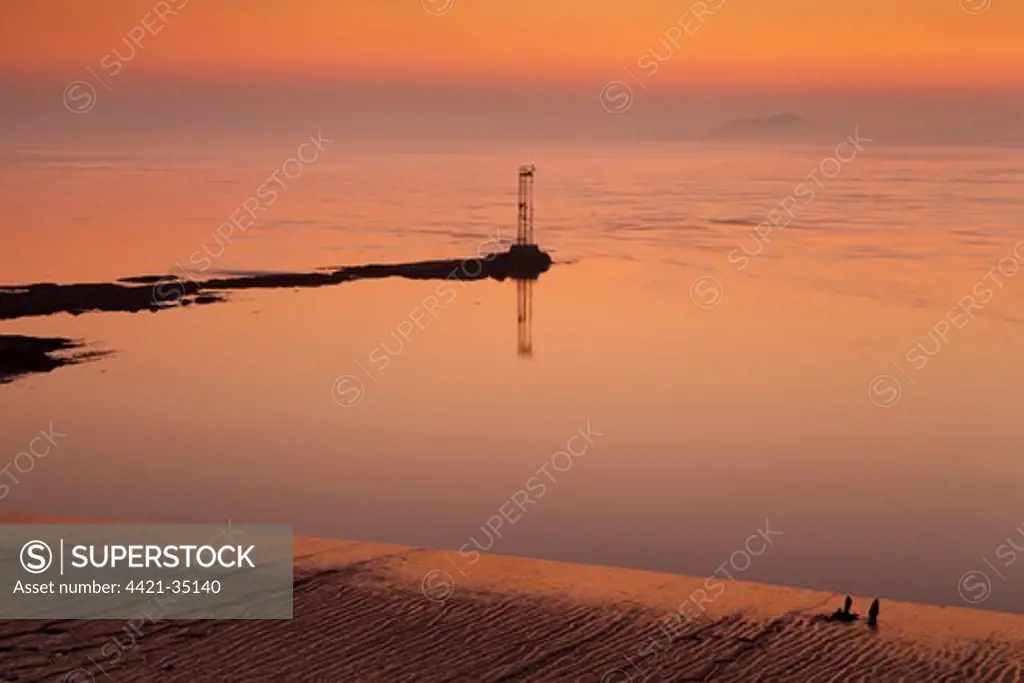 View over river estuary at dawn, with navigation light in foreground, viewed from near Chepstow, River Severn, Severn Estuary, Monmouthshire, Wales, september