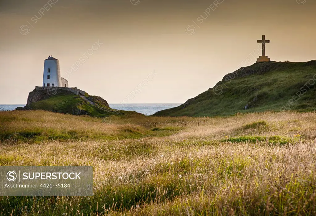 View of lighthouse, cross and coastline on tidal island, Llanddwyn Island, Newborough Warren National Nature Reserve, Newborough, Anglesey, Wales, August