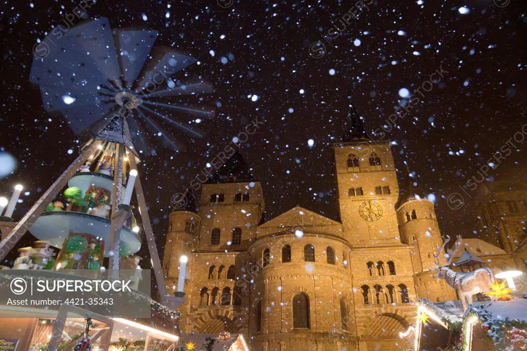 Christmas pyramid and market during snowfall at night, Cathedral of Saint Peter, Trier, Rhineland-Palatinate, Germany, december