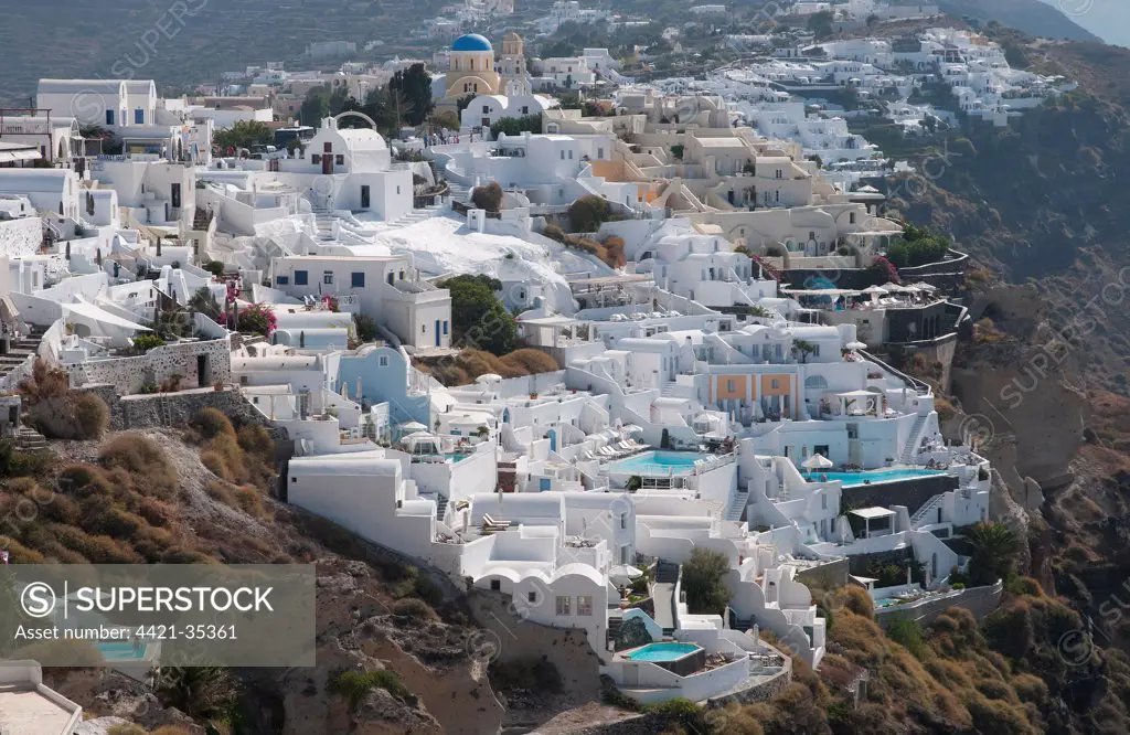 White-washed buildings and swimming pools, in town on coastal clifftop, Oia, Santorini, Cyclades, Aegean Sea, Greece, September