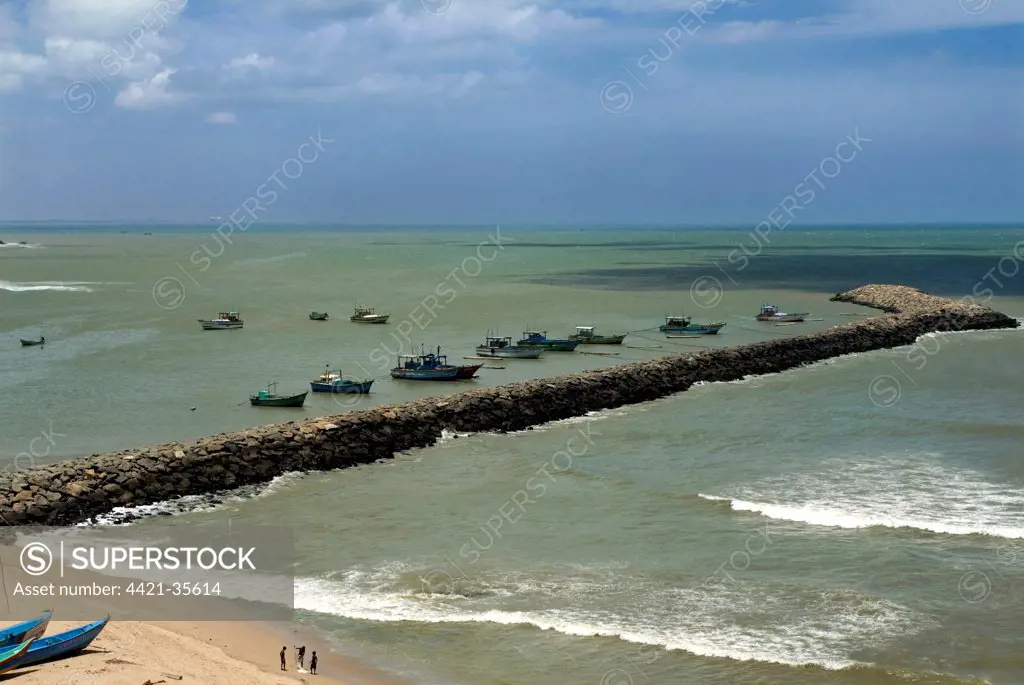 View of breakwater with moored fishing boats, confluence of Indian Ocean, Arabian Sea and Bay of Bengal, Kanyakumari (Cape Comorin), Tamil Nadu, India