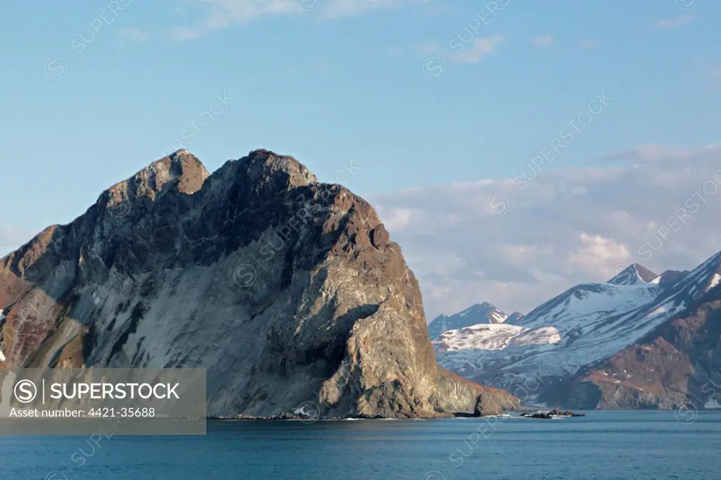 View of coastline with snow covered mountains, Bukhta Russkiya, Kamchatka Peninsula, Kamchatka Krai, Russian Far East, Russia, june