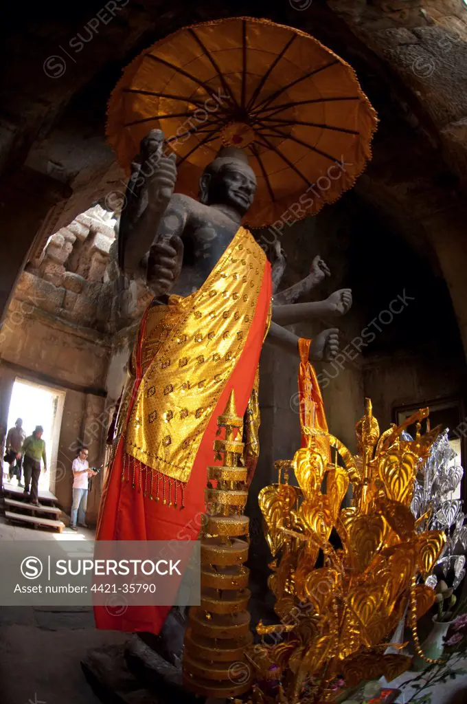Standing deity with umbrella in Khmer temple, Angkor Wat, Siem Riep, Cambodia