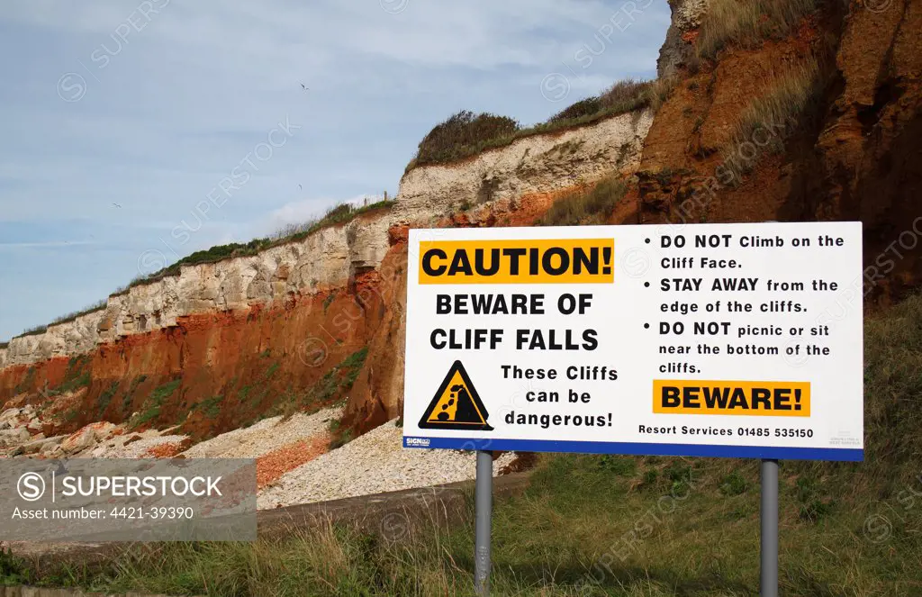 'Caution, Beware of Cliff Falls' warning sign, near chalk and carrstone sea cliffs, Hunstanton, Norfolk, England, october