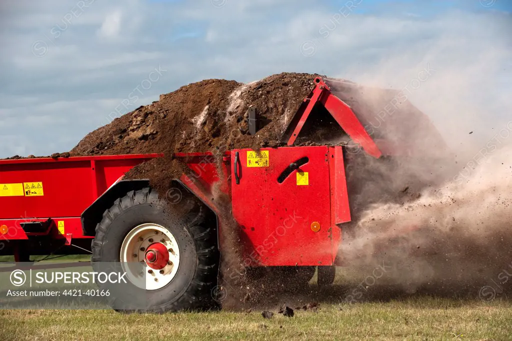 Close-up of muckspreader, spreading chicken manure mixed with lime on newly harvested meadow, England, june