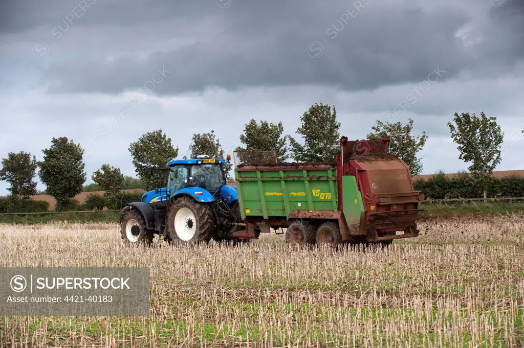 Tractor with muckspeader, spreading chicken manure on oilseed rape stubble field, Kelso, Scottish Borders, Scotland, september