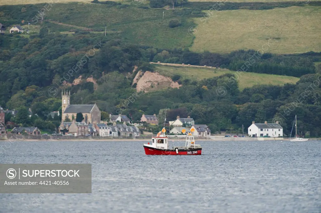 Small fishing boat at sea near coastal village, Moray Firth, Scotland