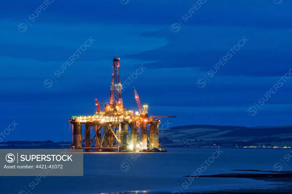 Oil rig moored in sea near coast at night, Cromarty Firth, Moray Firth, Invergordon, Easter Ross, Scotland