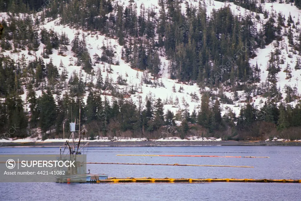 Tug moving oil boom into position, following Exxon Valdez Disaster, Prince William Sound, Alaska, U.S.A.