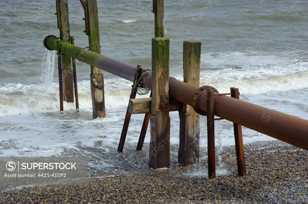 Drain pipe emptying into sea, Weybourne, Norfolk, England, may