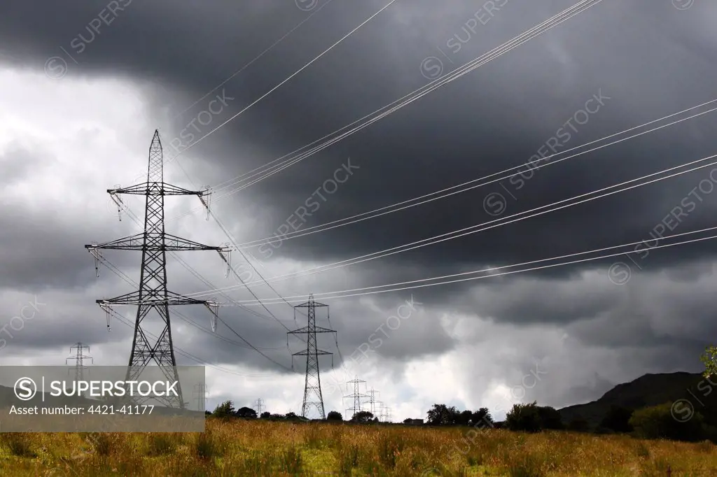 Electricity transmission pylons and stormclouds, above Conwy Valley, Carneddau Mountain Range, Snowdonia N.P., North Wales, june