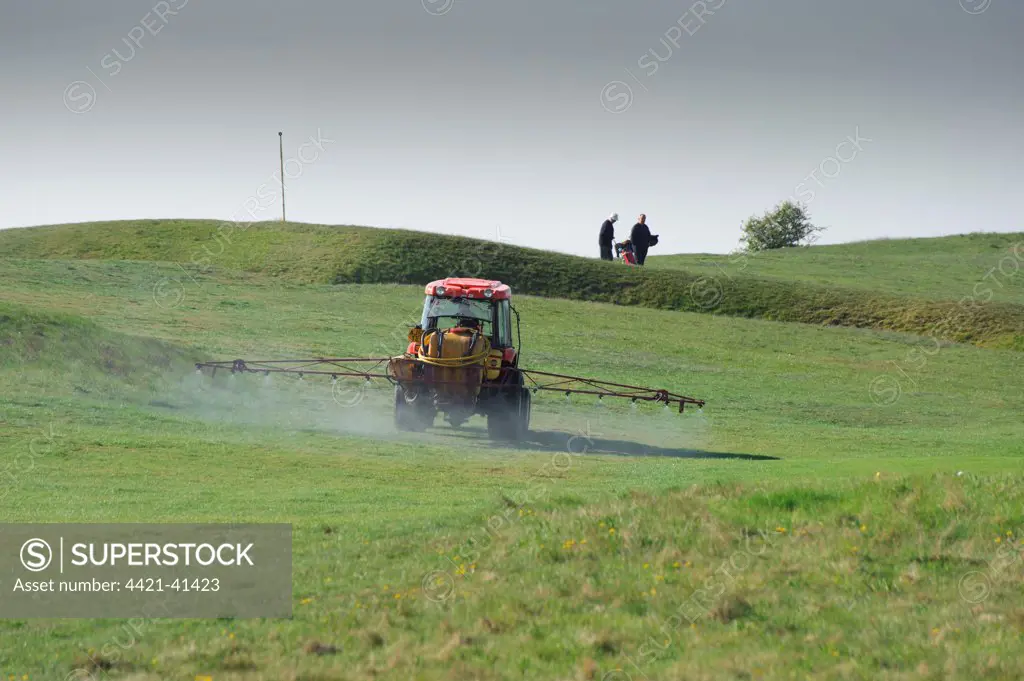 Tractor with sprayer, spraying on golf course, Skegness, Lincolnshire, England, april