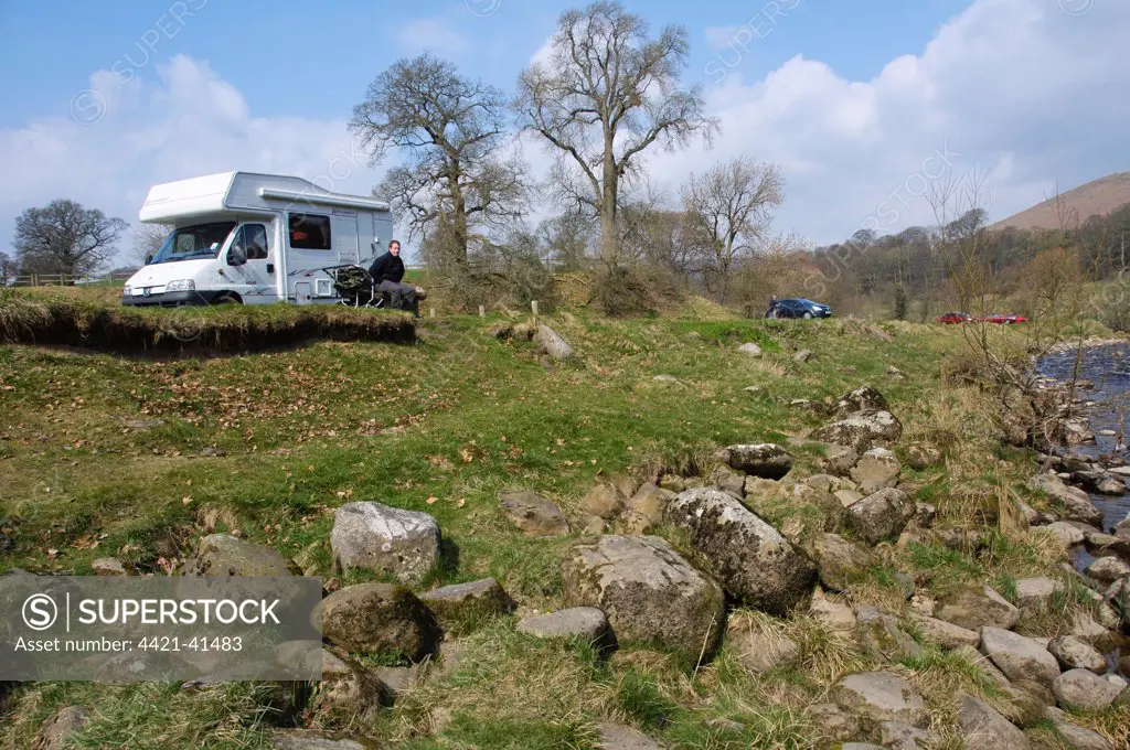 Motorhome and cars parked near riverbank, River Wharfe, Bolton Abbey, North Yorkshire, England, march