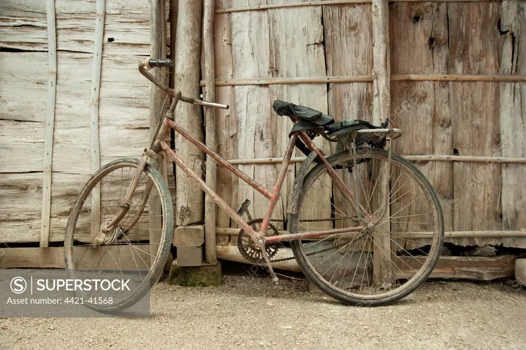 Rusty old bike leaning against wooden fence, Cepu, Java, Indonesia