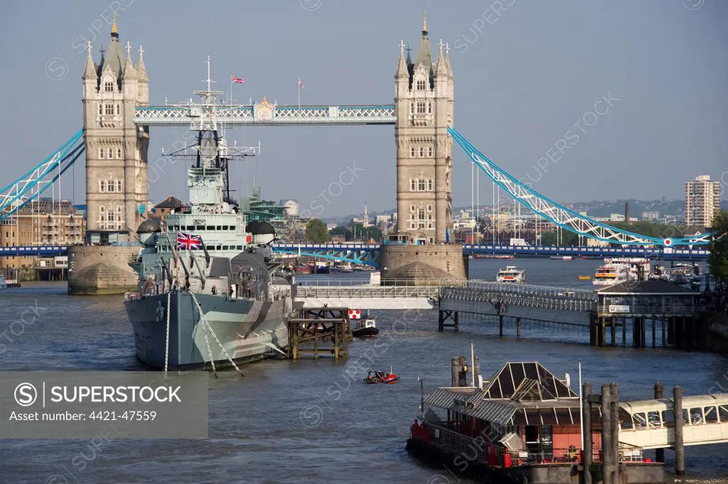 View of HMS Belfast museum ship moored on river in city, Tower Bridge, River Thames, London, England, april