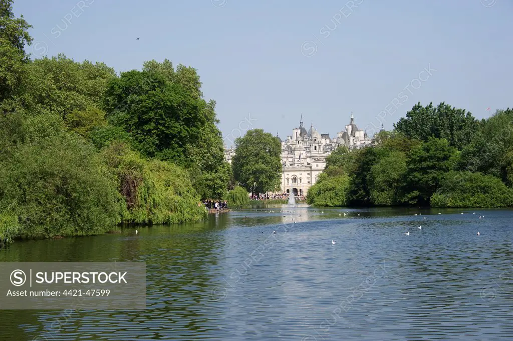 View across lake in urban parkland towards Horse Guards, St. James's Park Lake, St. James's Park, City of Westminster, London, England, april