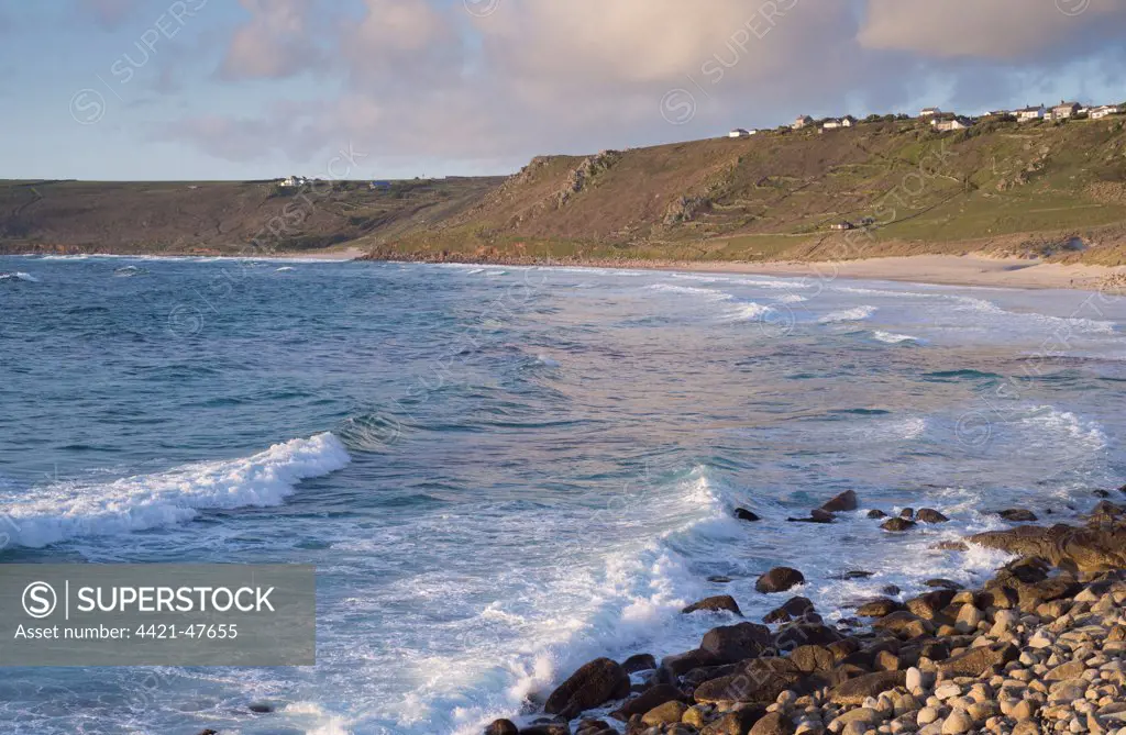 View of waves and coastline in evening sunlight, Sennen Cove, Sennen, Cornwall, England, May