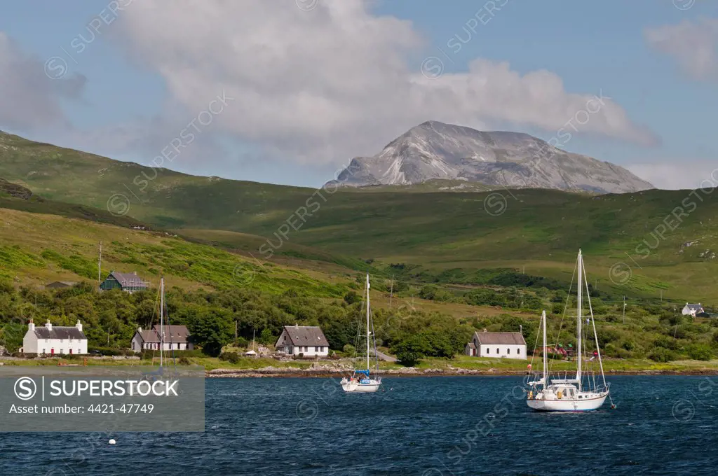 View of yachts moored in bay, with Beinn an Oir, Paps of Jura in background, Craighouse Bay, Isle of Jura, Inner Hebrides, Scotland