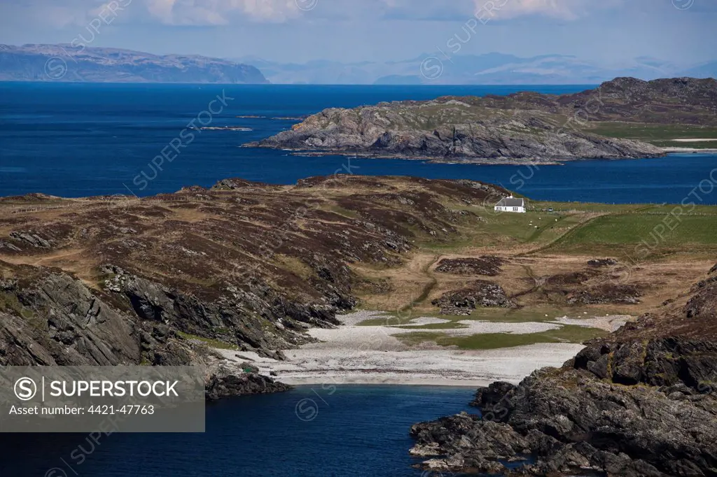 View of northwest coastline with raised beach and lone house, Port nam Fliuchan, Isle of Colonsay, Inner Hebrides, Scotland