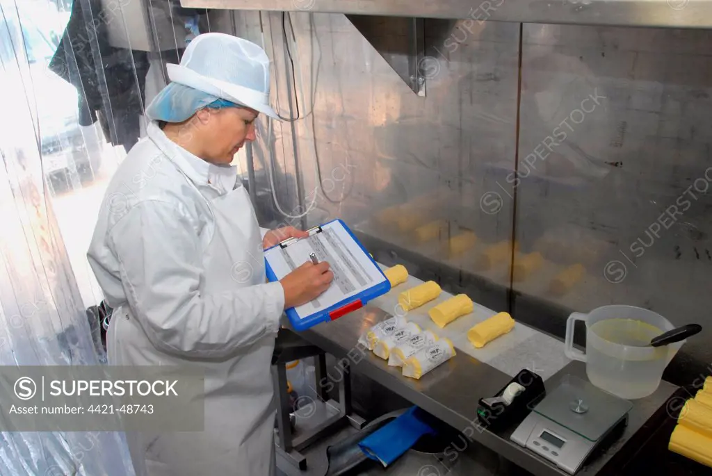 Worker recording batch of organically made butter from unpasteurized milk, on organic dairy farm, Hook and Son, Longleys Farm, near Hailsham, Pevensey Levels, East Sussex, England, April