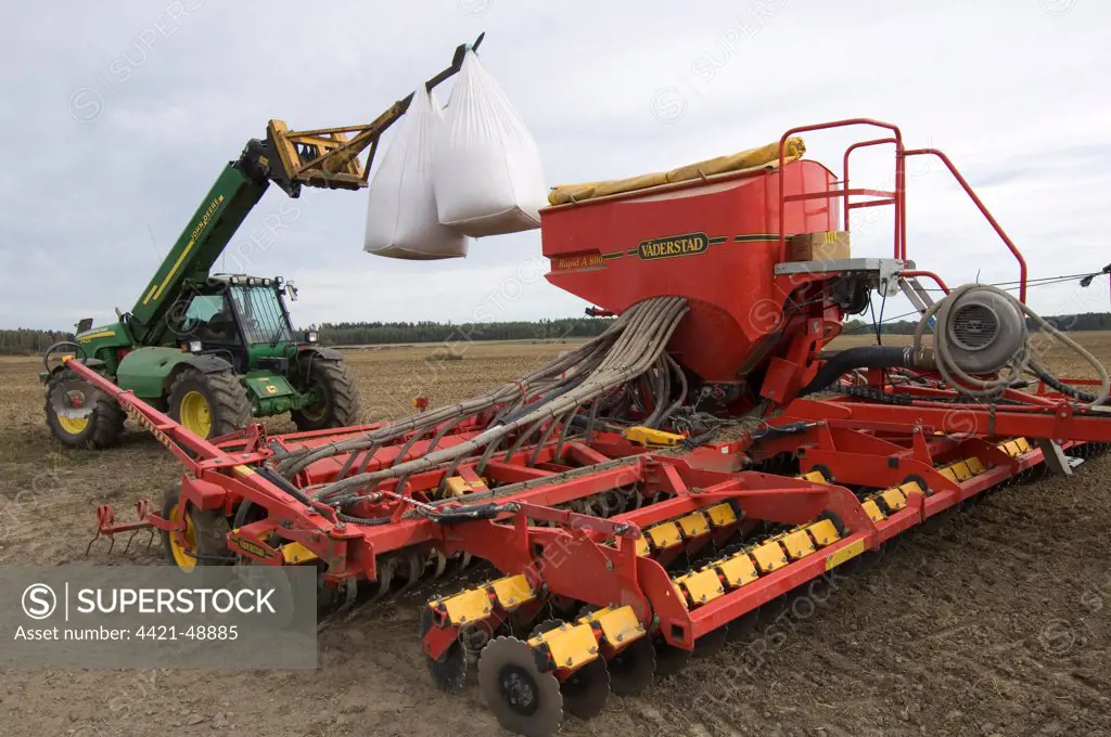 John Deere 3400 telehandler with bags of wheat seed, loading Vaderstad seed drill, Sweden, autumn