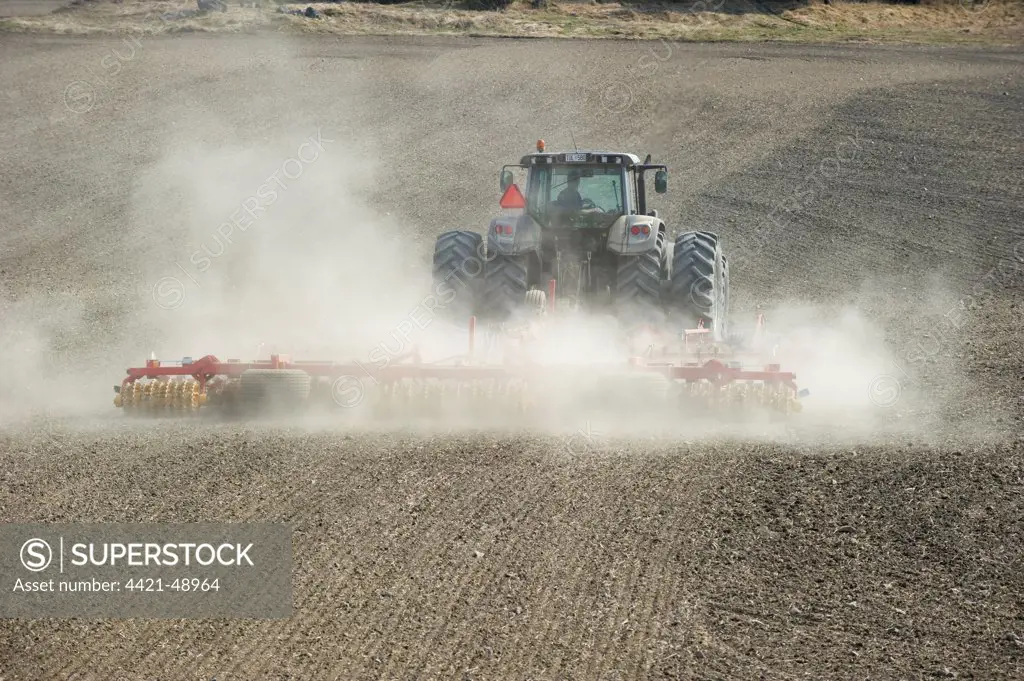Valtra tractor with Vaderstad NZA-800 and Vaderstad RS-820 harrows and rollers, cultivating dusty arable field, Sweden, april