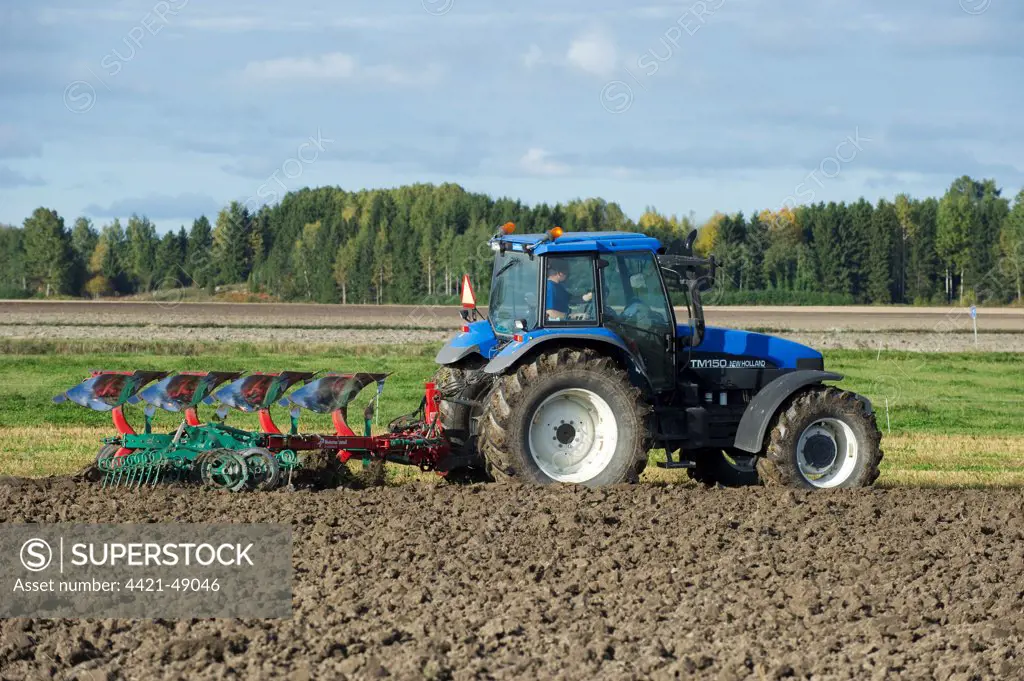 New Holland TM150 tractor with reversible plough and harrow, ploughing arable field, Sweden, september