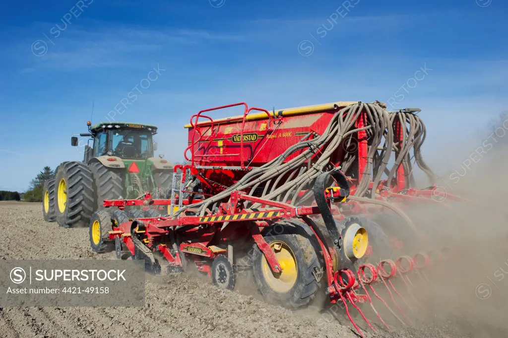 John Deere 7280R tractor with Vaderstad Rapid A 600C seed drill, drilling Oilseed Rape (Brassica napus) crop in arable field, Rosersberg, Stockholm County, Sweden, may